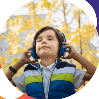 A child with headphones on, eyes closed, listening to music outdoors